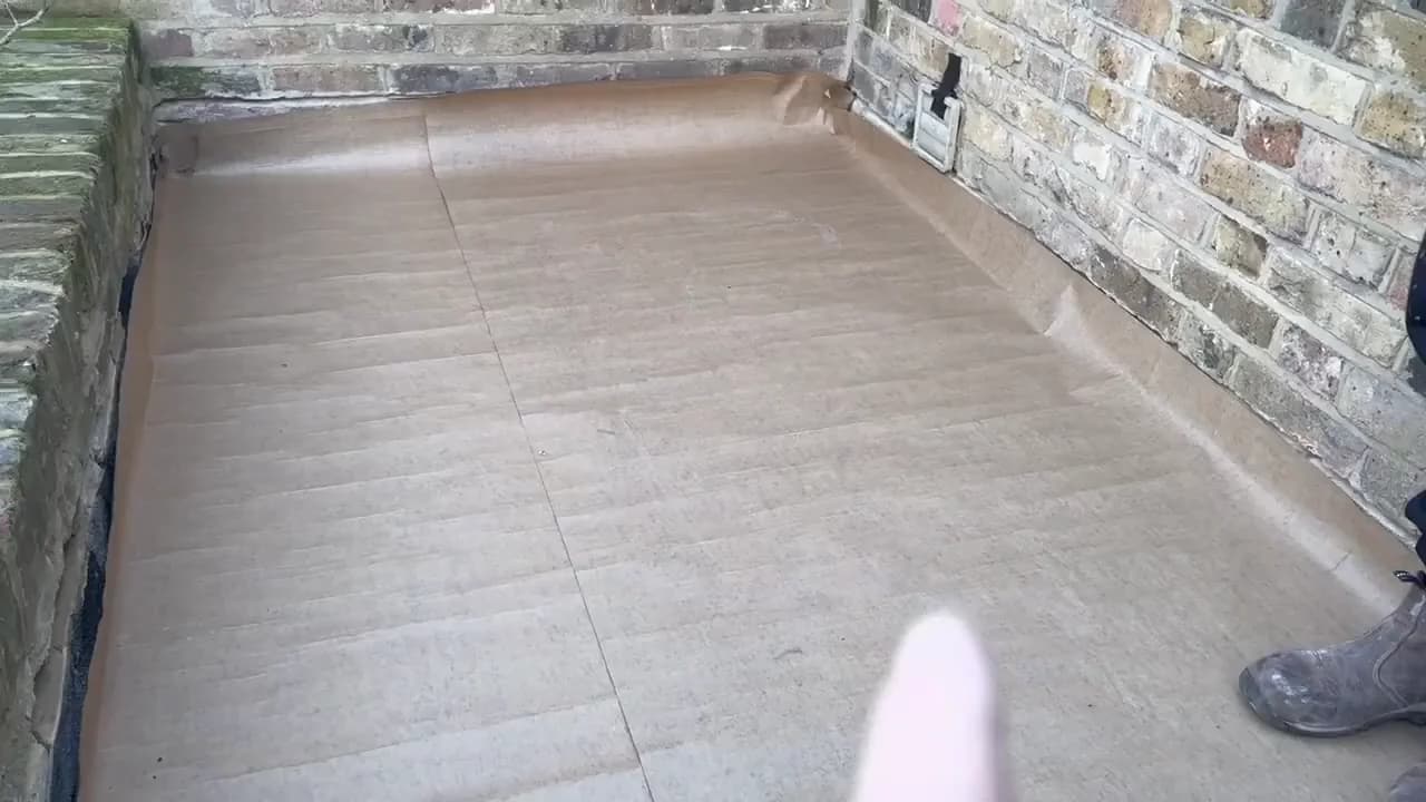 Building paper laid over the boarded flat-roof deck before leadwork