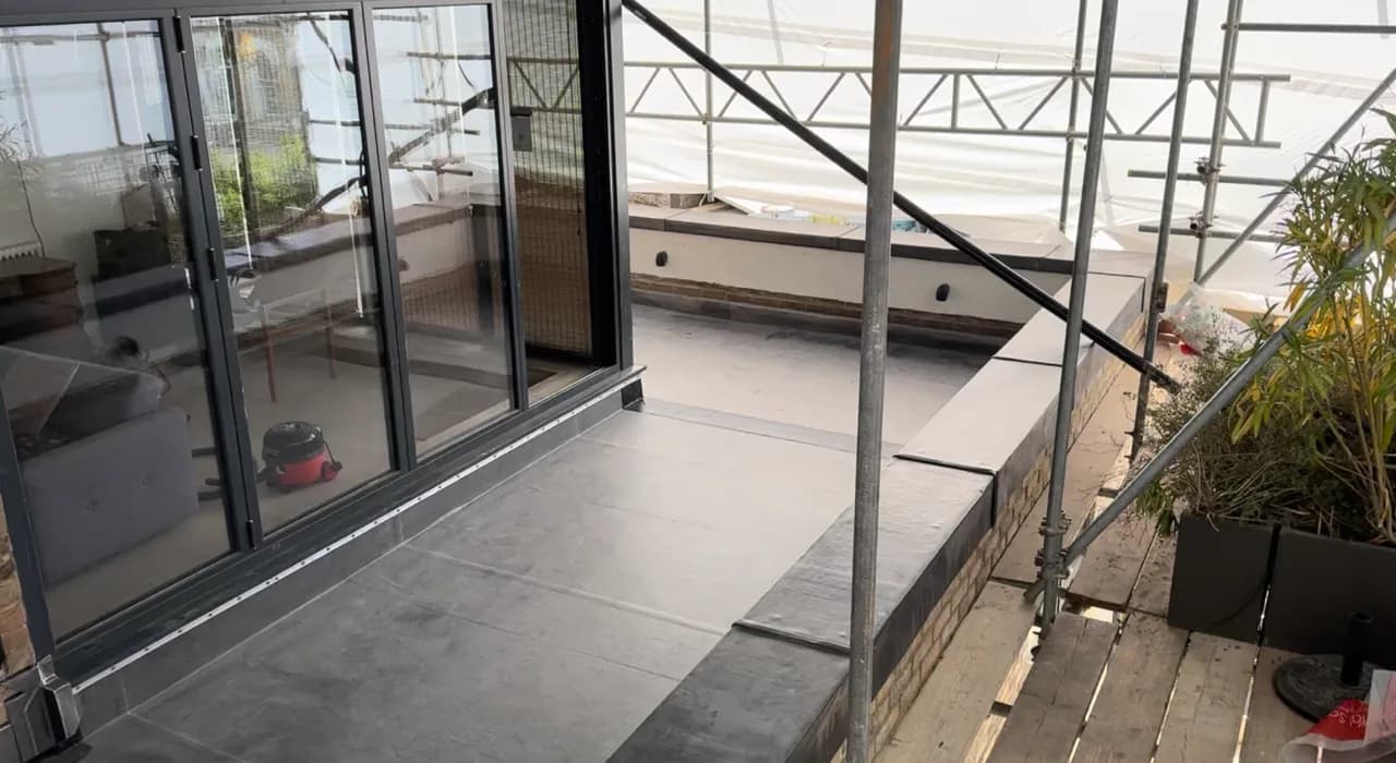 Completed flat roof membrane around a glazed roof opening