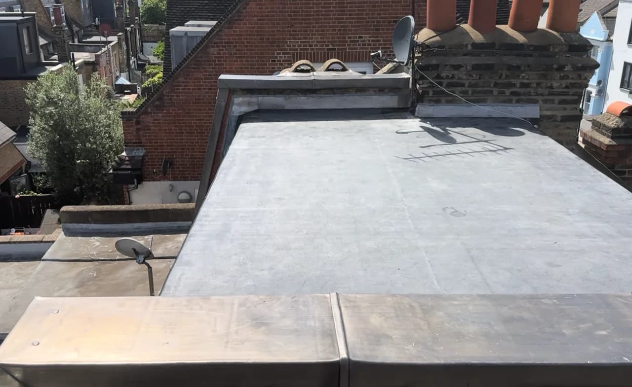 Finished flat roof covering with sealed upstands and perimeter details