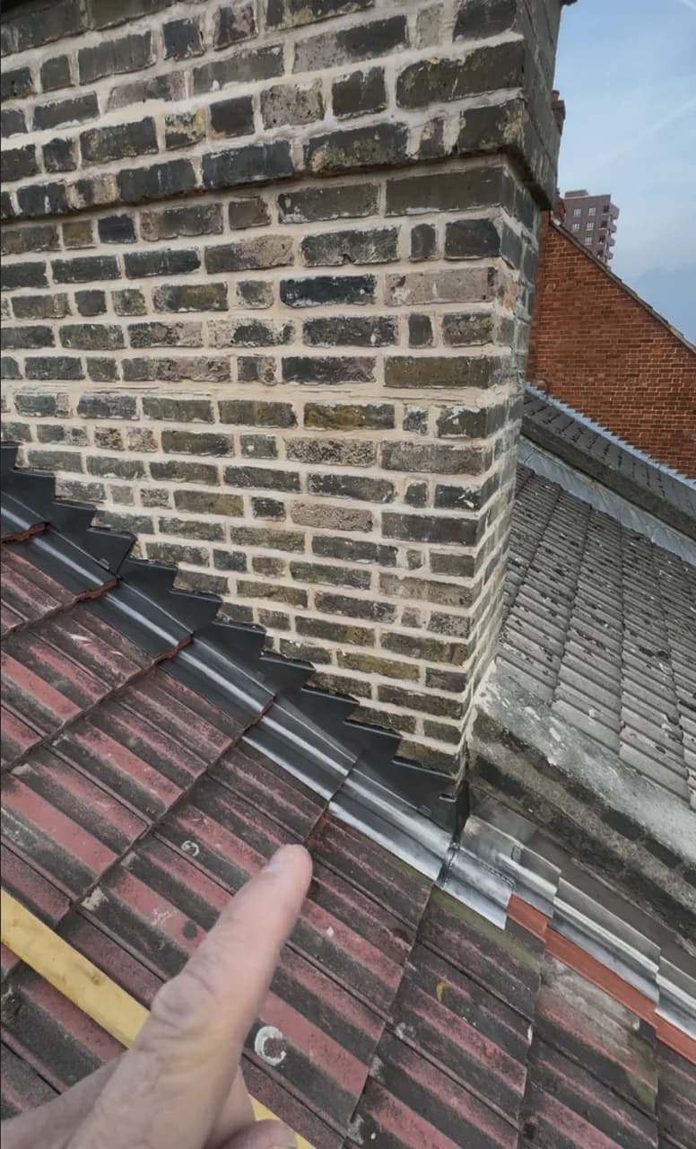 Stepped lead flashing formed around a brick chimney