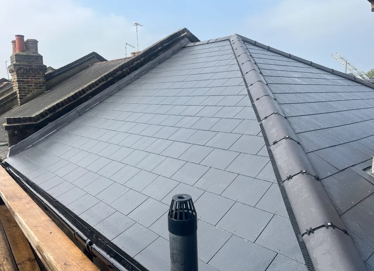 Completed hipped slate roof with finished ridge and perimeter