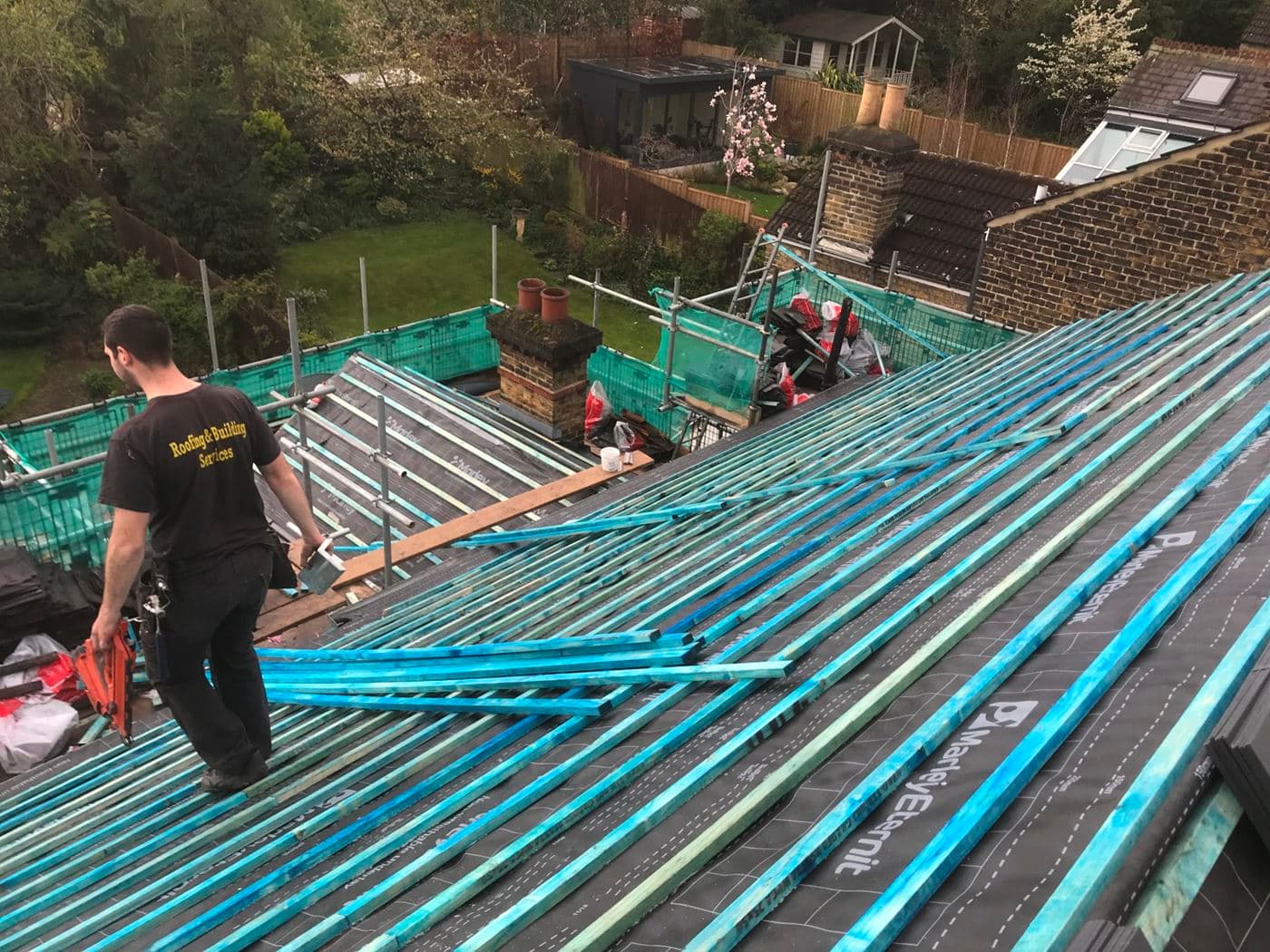 picture of man waking on a roof being repaired
